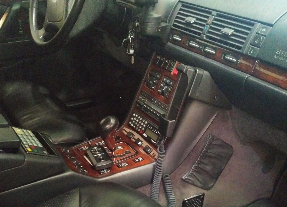 Font eines Mercedes Benz mit Holzarmaturen und einer Ladeschalenhalterung für ein Autotelefon